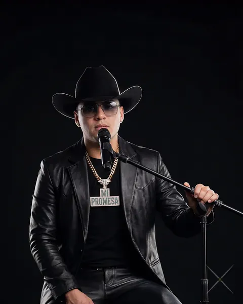 Avatar de Yeison Jiménez sentado con sombrero y chaqueta de cuero negro, cantando Ya No mi Amor